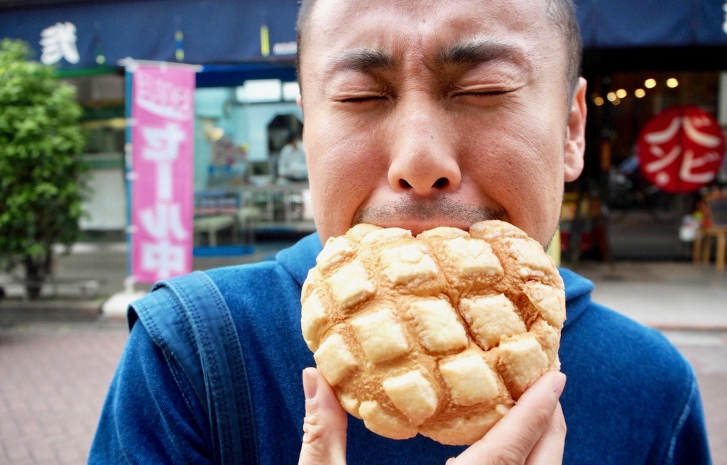 お店の前でメロンパンをガブリ