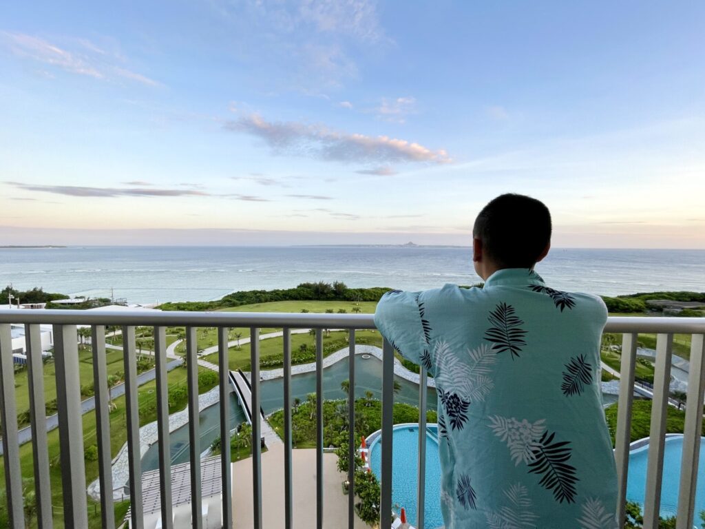 「ヒルトン瀬底」ナイトウエアを着て朝焼けを眺める様子