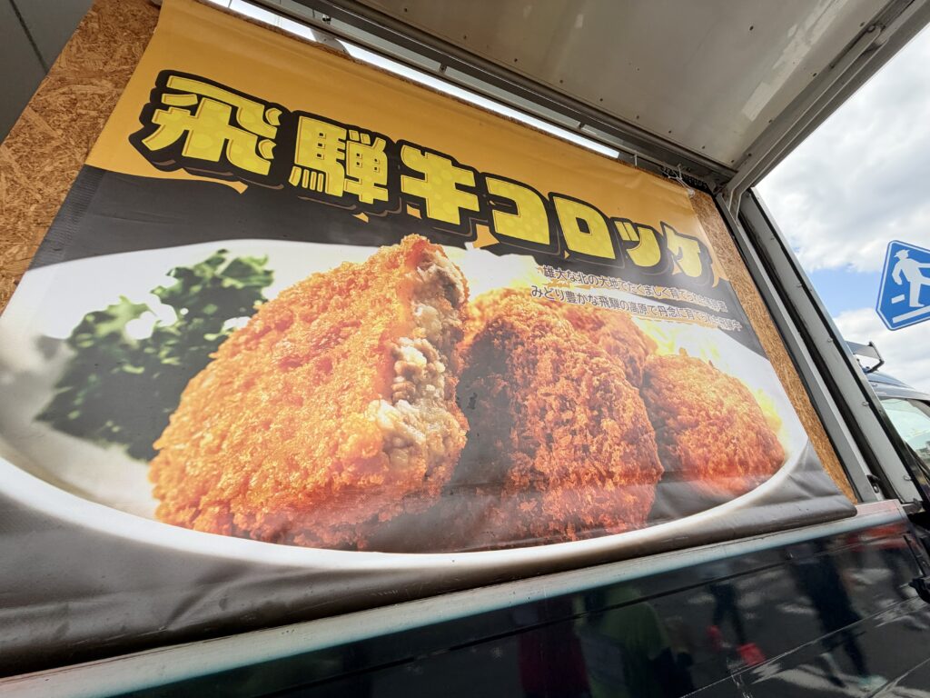ぎふ清流ハーフマラソン 給食エイド 飛騨牛コロッケの看板